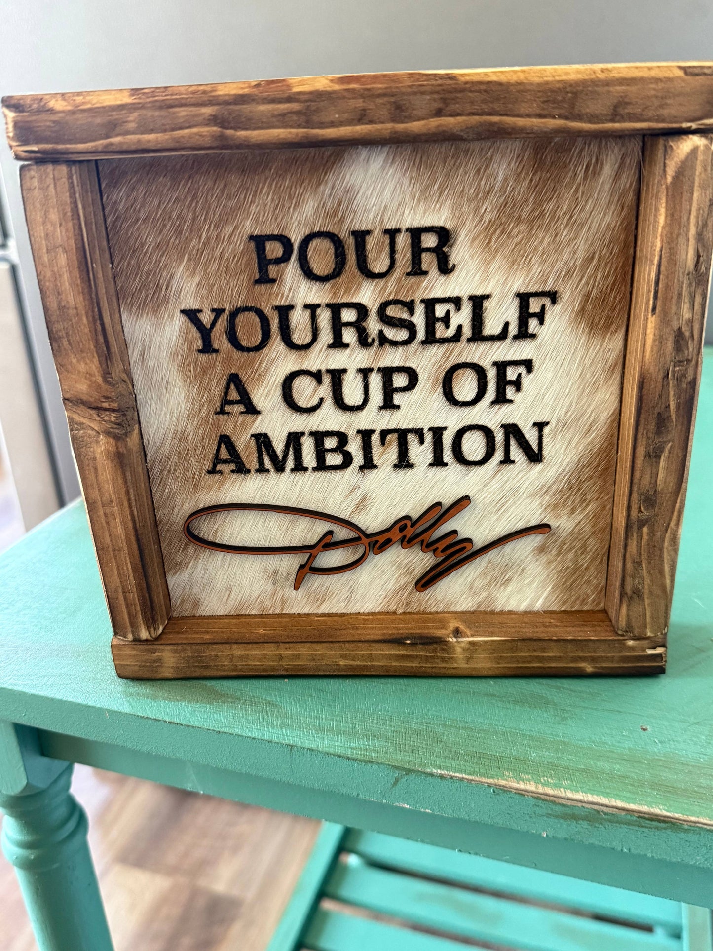 DOLLY PARTON FRAMED COWHIDE SIGN - POUR YOURSELF A CUP OF AMBITION!